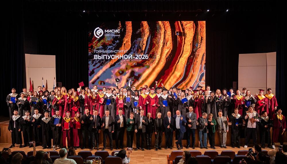 Выпускники Горного института НИТУ МИСИС стоят с дипломами на сцене